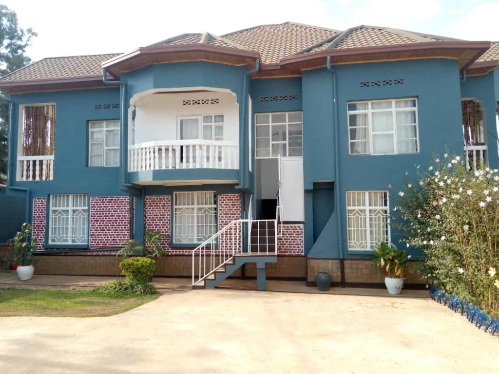 ein blaues Haus mit einer Treppe davor in der Unterkunft Stunning 6-Bed Apartment in Kigali in Kigali