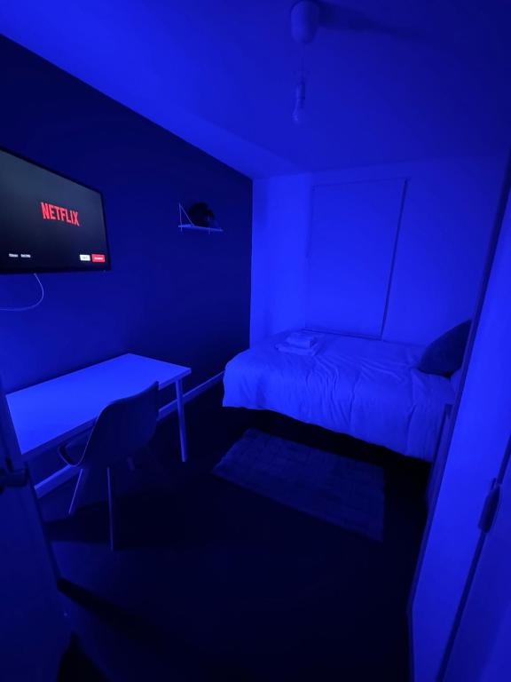 a dark room with a bed and a tv at Deluxe Ensuite studio in west midlands in Coventry