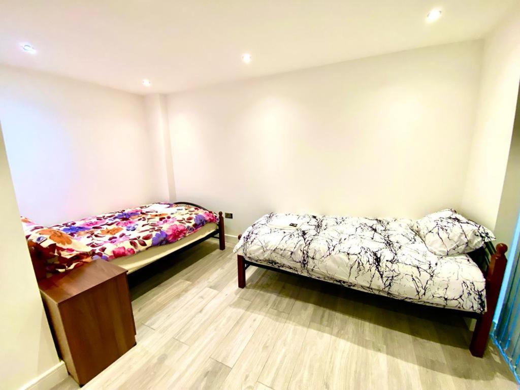 a room with two beds and a couch in it at Comfortable One Bedroom Flat with free Car Park in London in London