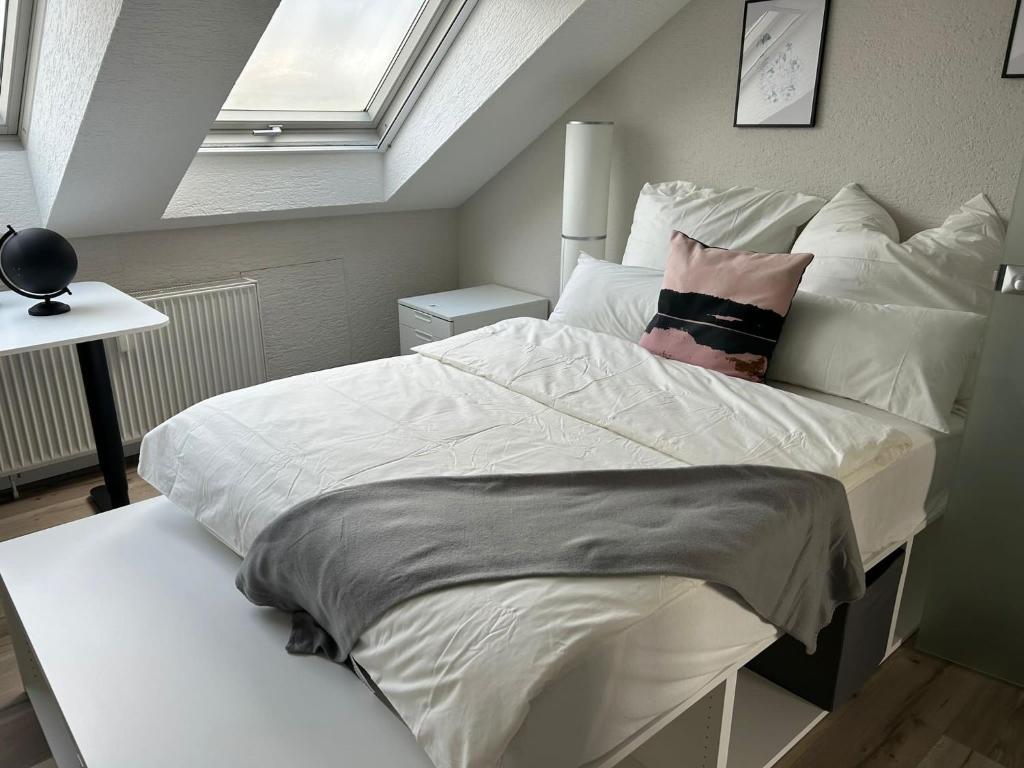 a bedroom with a bed with white sheets and pillows at Saarbrücken City Saar in Saarbrücken