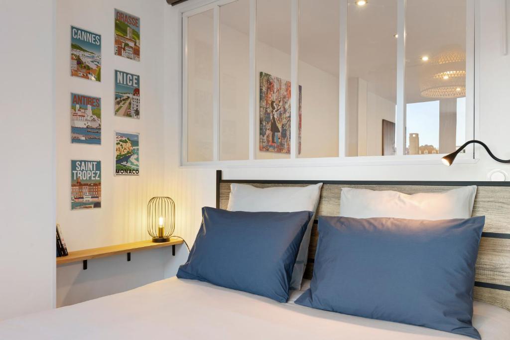 a bedroom with a bed with blue pillows at Private Apartment - Family - Palais des Festival - Parking - Cannes in Cannes