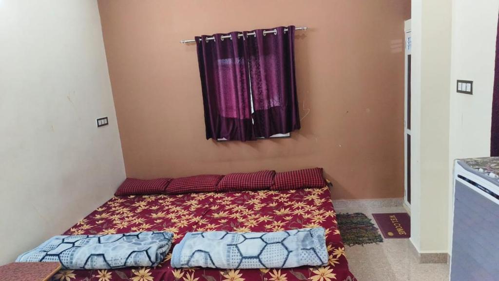 um pequeno quarto com uma cama e uma janela em Kavya Home stay em Ujaim