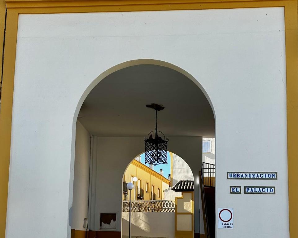 een boog in een gebouw met een kroonluchter bij Casa rural Campiña de Sevilla Tranquila y familiar 