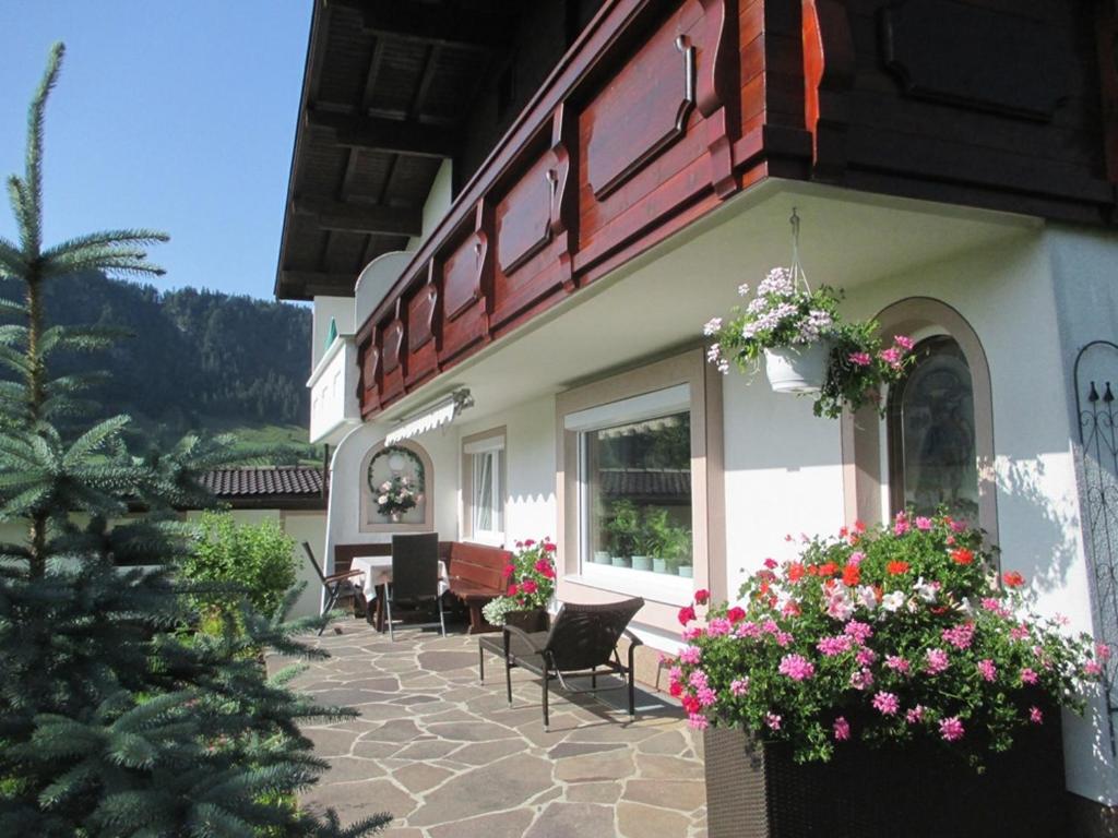 ein Gebäude mit Stühlen und Blumen auf einer Terrasse in der Unterkunft Haus Birgit in Walchsee