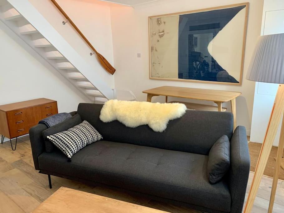 a living room with a couch and a table at Luxurious cottage in the heart of Falmouth in Falmouth