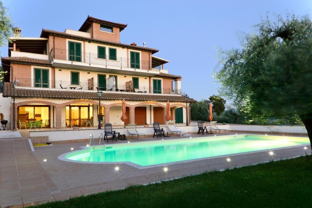 a large house with a swimming pool in front of it at Bed and Breakfast Ocarè in San Gemini
