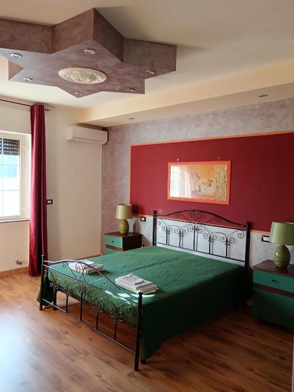 SupersanoにあるLu Sule B&Bの赤い壁のベッドルーム1室(緑のベッド1台付)
