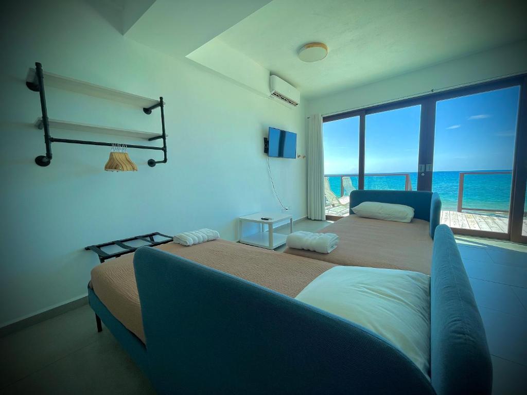 Postel nebo postele na pokoji v ubytování 1 Corcega Beachfront Suites
