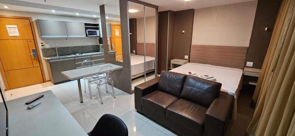 a living room with a couch and a bed in a room at Flat particular no Hotel Jade Park Sul Brasília B812 in Brasilia