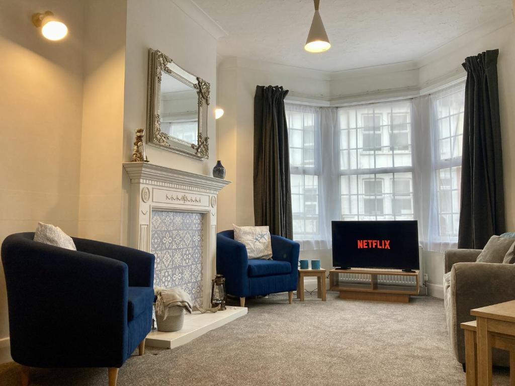 a living room with a fireplace and a tv at Fairfax in Southend-on-Sea