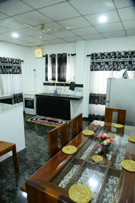 a kitchen with a table with chairs and a refrigerator at GK Home Stay in Hikkaduwa