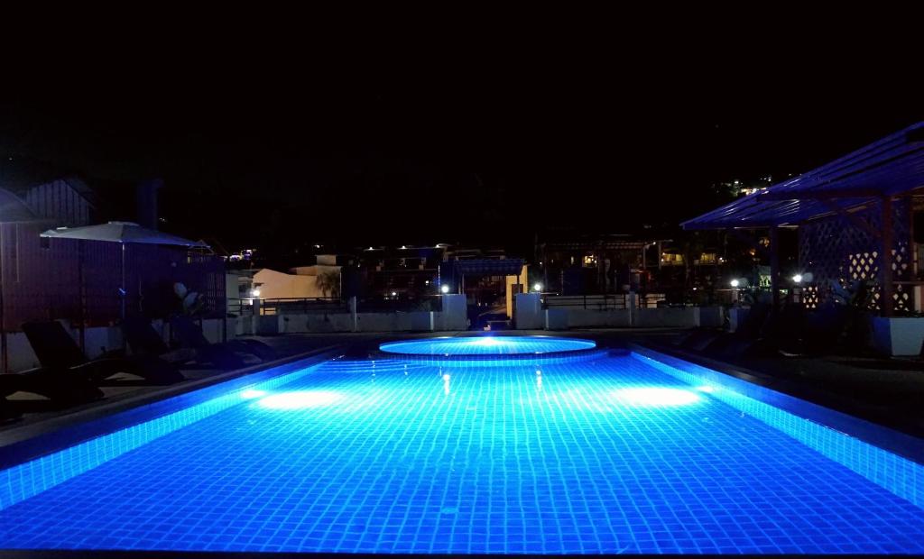 una piscina por la noche con luces azules en Odin Andaman Hotel en Patong