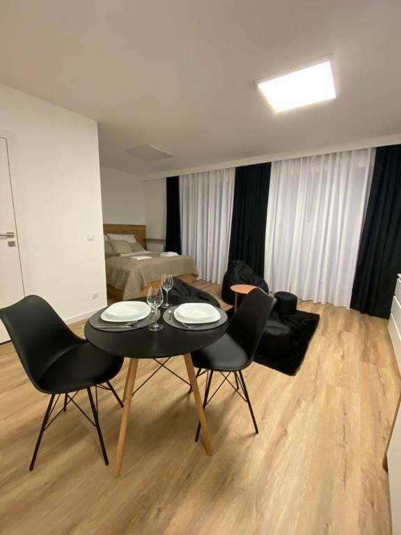 a living room with a black table and chairs at Apartament Cicha 16B2 in Krynica Zdrój