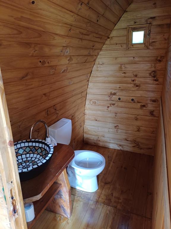 un bagno con servizi igienici in una cabina di legno di Hostel Chacra La Templanza a El Hoyo