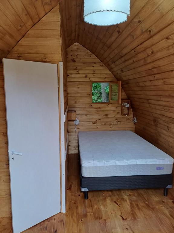una camera da letto con un letto in una stanza di legno di Hostel Chacra La Templanza a El Hoyo