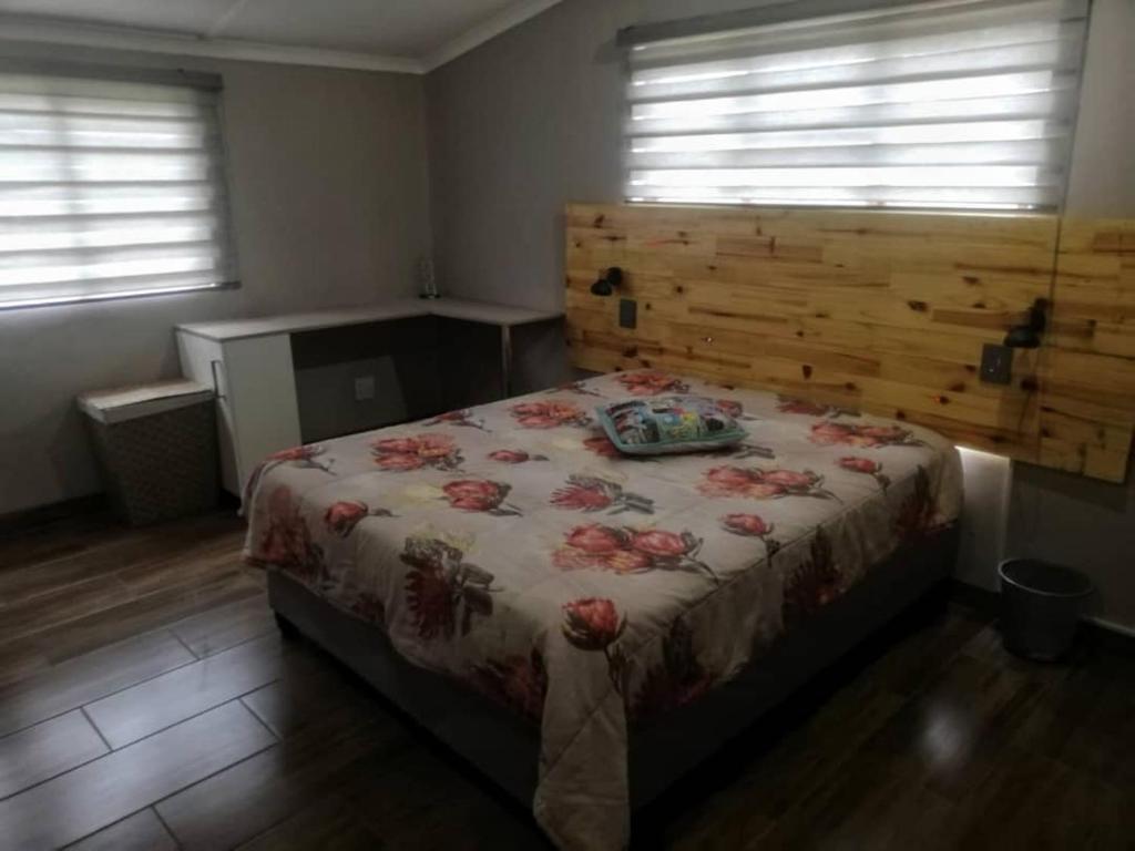 a bedroom with a bed with a floral bedspread on it at SHALOM in Margate