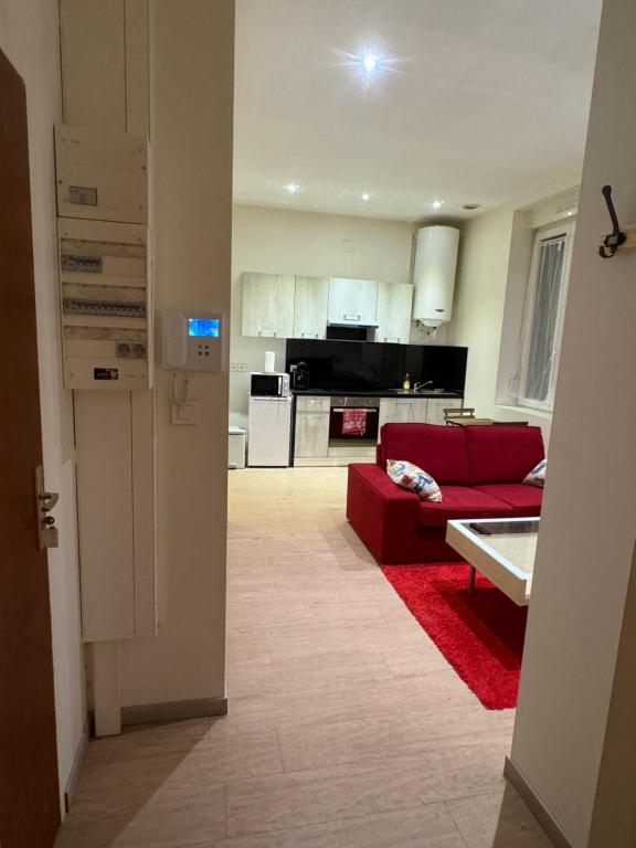 a living room with a red couch and a kitchen at Christelle in Romilly-sur-Seine