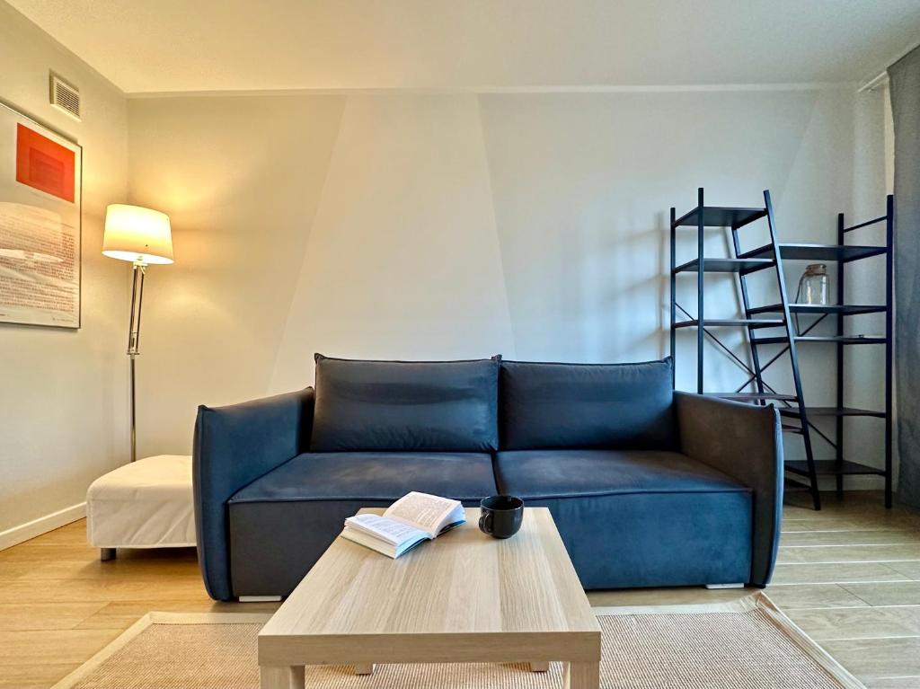 a living room with a blue couch and a coffee table at Apartament Willow in Gdańsk