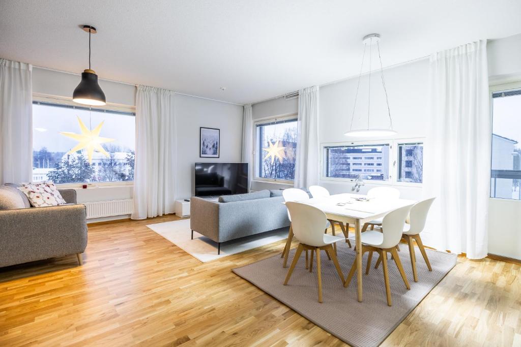 un soggiorno con tavolo, sedie e divano di Nordic Design Apartment City Center a Rovaniemi