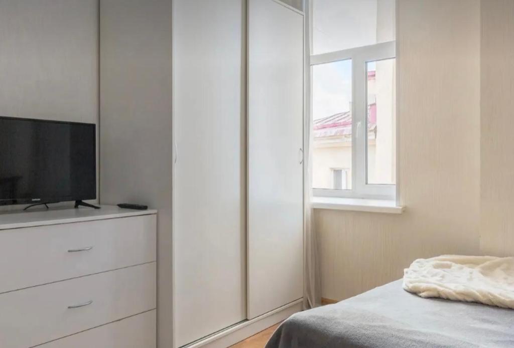 - une chambre avec une commode, une télévision et une fenêtre dans l'établissement VIP apart 768, à Tbilissi