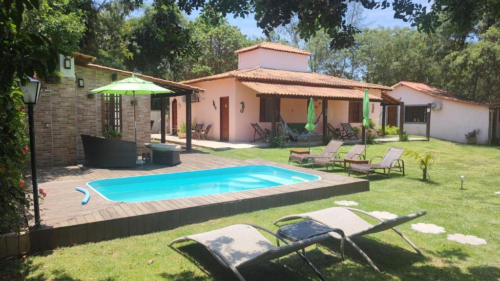 a backyard with a swimming pool and a house at Marina Guest House in Búzios