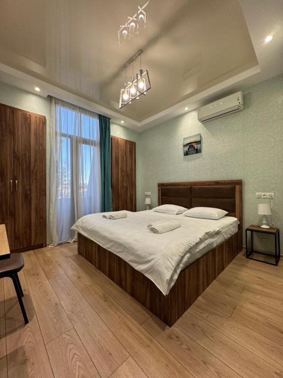 een slaapkamer met een groot bed in een kamer bij Veranda L&G in Koetaisi