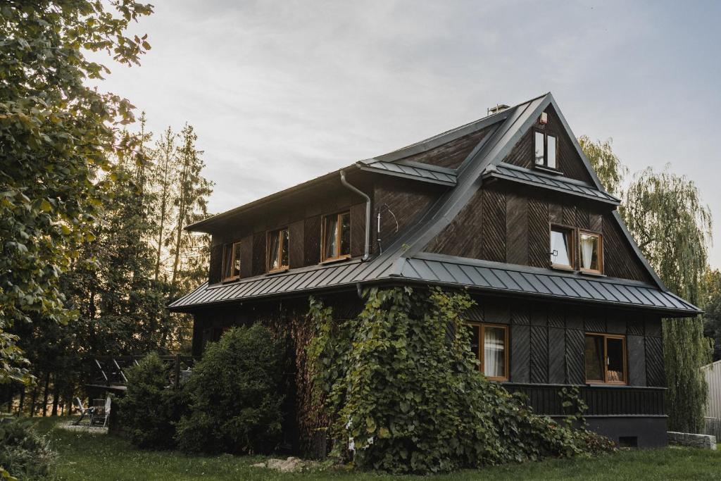 una casa con hiedra creciendo a su lado en Stara Leśniczówka, en Godkowo