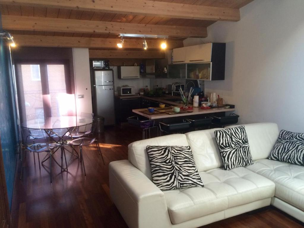 ペスカーラにあるL'Incantesimoのリビングルーム(白いソファ付)、キッチンが備わります。