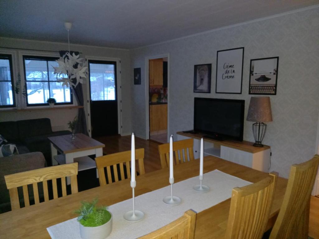 a dining room and living room with a table and a television at Smålandshus in Målilla