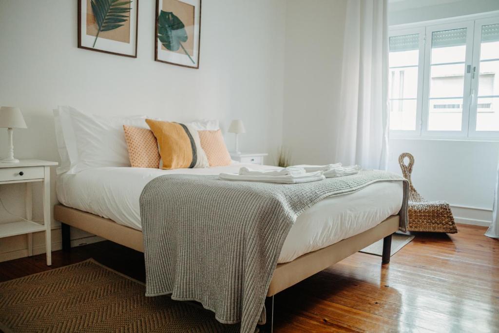 Un dormitorio con una cama con una manta. en Belém Tejo - Jardim en Lisboa
