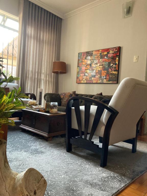 a living room with a couch and a table at Casa Vintage, tranquilidade no Prado in Belo Horizonte