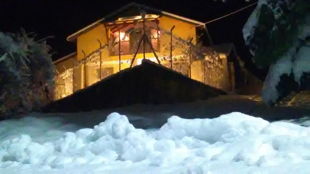 una casa con un montón de nieve delante de ella en Drazilovo, en Metamórfosi