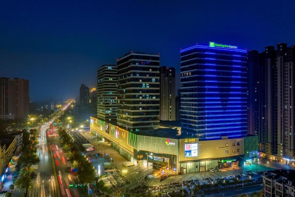 miasto oświetlone nocą budynkami w obiekcie Holiday Inn Express Heze City Center, an IHG Hotel w mieście Heze