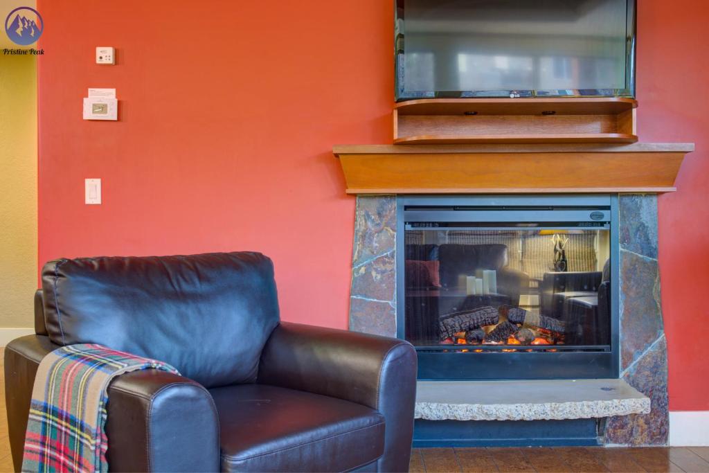 a leather chair sitting in front of a fireplace at Chinook Manor in Canmore