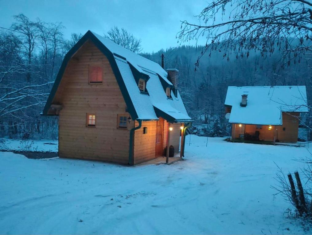 una casa con nieve en el techo en la nieve en Vikendica Đoković 2 - Jahorina en Pale