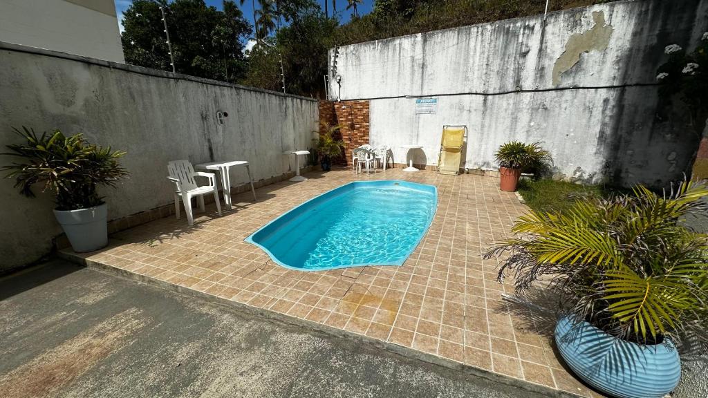 a swimming pool in a backyard with a table and chairs at Apt. em Praia do Sul de Ilhéus in Ilhéus