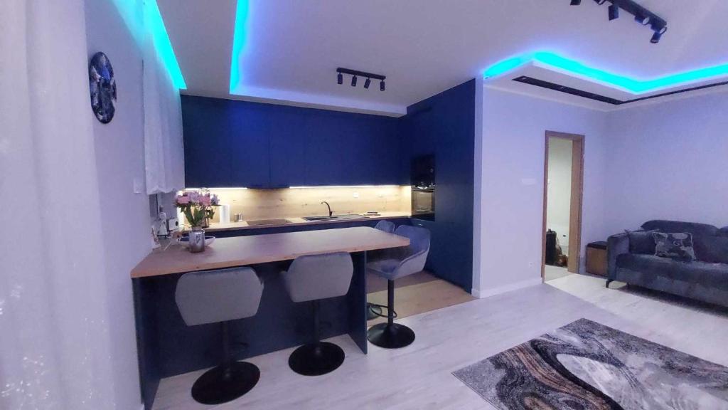 a kitchen with a sink and a blue wall at Bee Happy Apartament Wrzesnia ll in Września