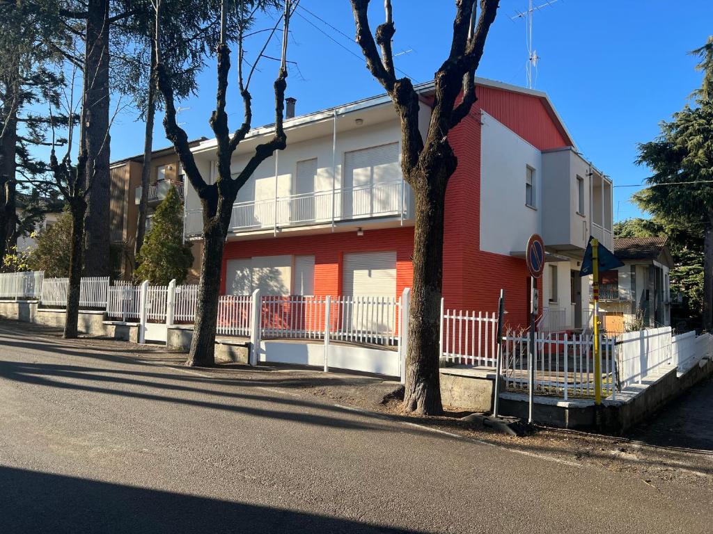 un bâtiment rouge et blanc sur le côté d'une rue dans l'établissement La casa sui colli bolognesi, à Savigno