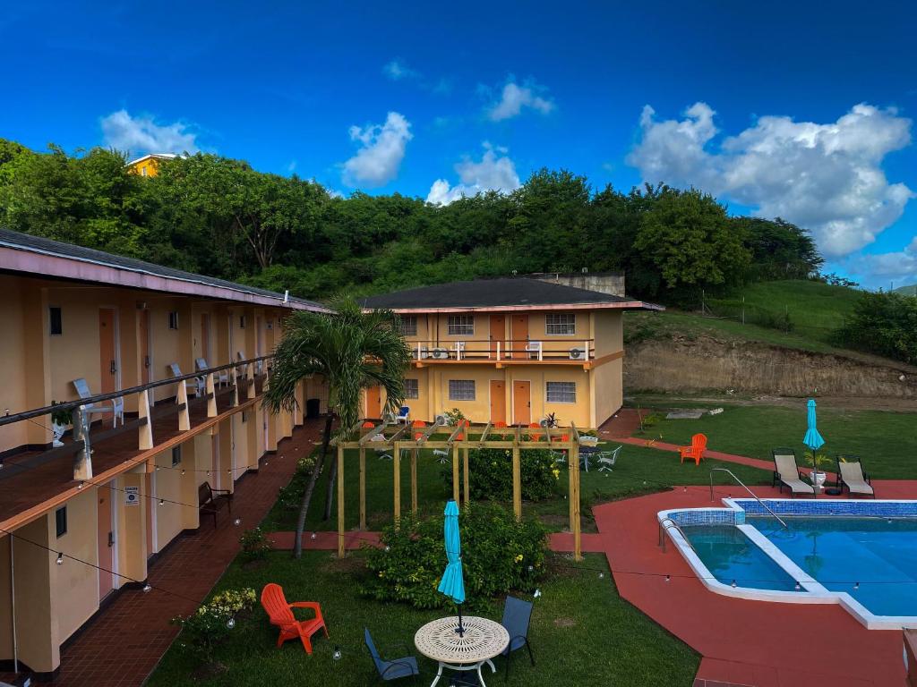 a resort with a swimming pool and a building at Point Salines Hotel in Gwa Kay