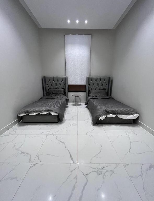 two beds in a room with marble floors at بببببب 