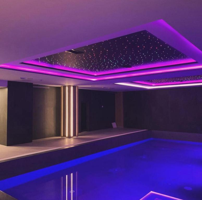 a room with a swimming pool with purple lighting at Apart hotel Zlatni Javor - Trio in Jahorina