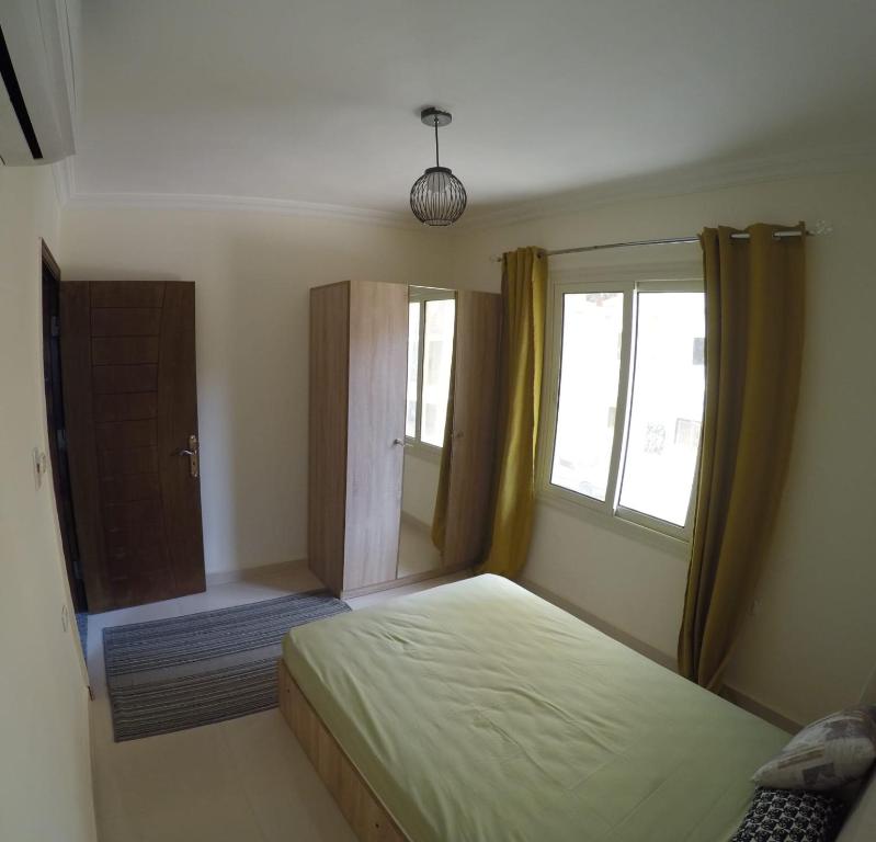 een slaapkamer met een bed en een raam bij Andalusia Resort - 2 Bedroom Apartment in Hurghada