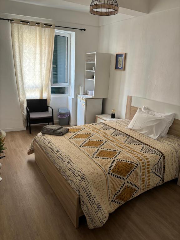 una camera con un letto e una sedia e una finestra di Cc39 -Q1 a Funchal