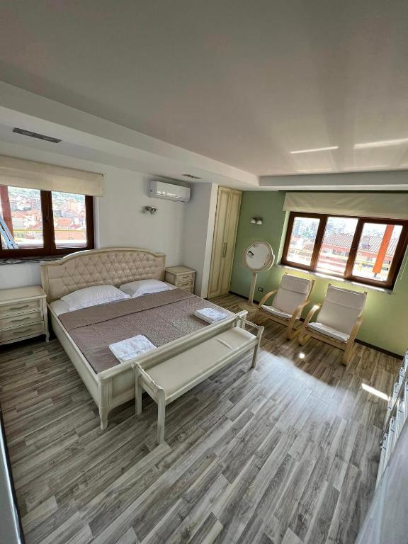 波格拉德茨的住宿－Apartament Pogradeci，一间卧室配有一张大床和两把椅子