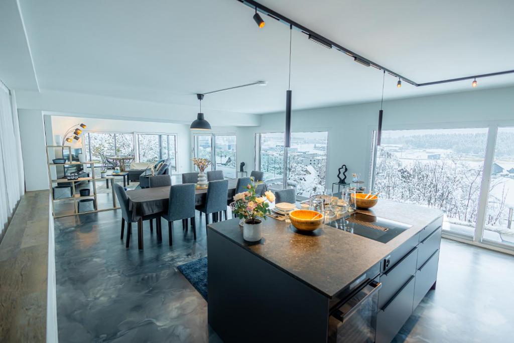 cocina y comedor con ventana grande en Visionary Hospitality - Big Premium Loft with View, Washer, Parking, Kitchen, Tub, en Dierikon