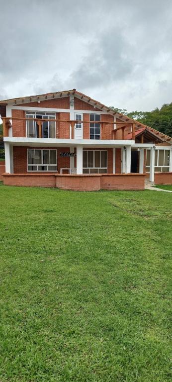 ein großes Backsteingebäude mit einer grünen Wiese davor in der Unterkunft FINCA VILLA BLANCA in Termales