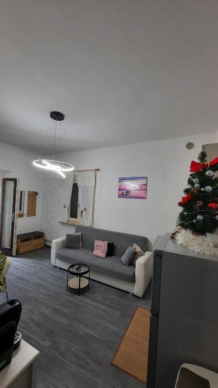 een woonkamer met een bank en een kerstboom bij Cuore di Toscana, 44 in San Marziale