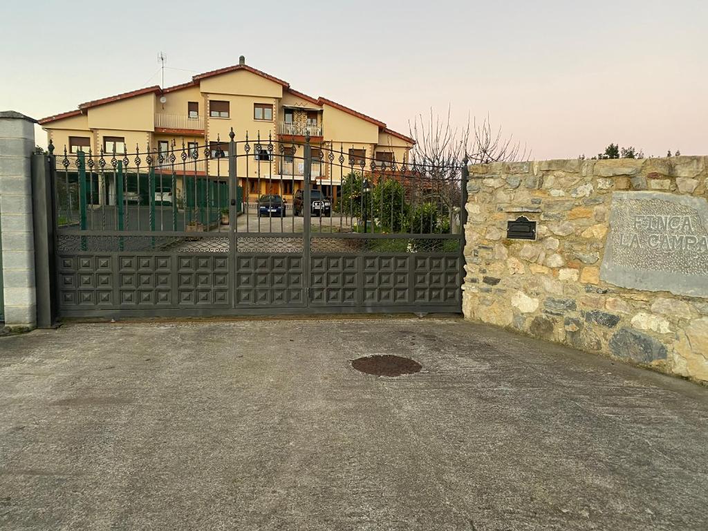 a gate in front of a house with a fence at Alojamiento Finca La Campa in Mareo de Abajo