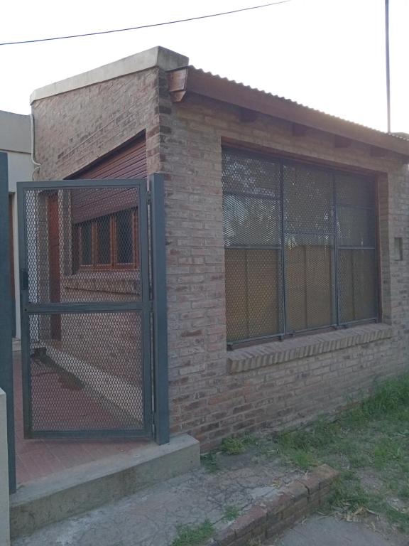 una valla frente a un edificio de ladrillo en (El departamento) en Pergamino
