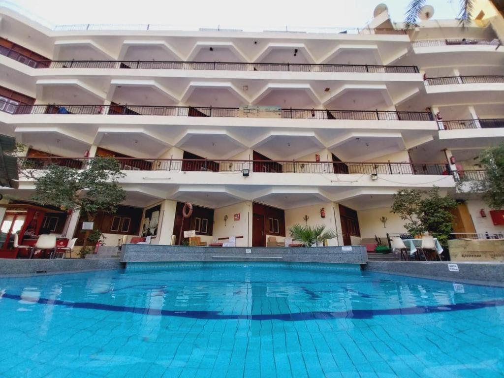 a large building with a large swimming pool at Rezeiky Hotel & Camp in Luxor